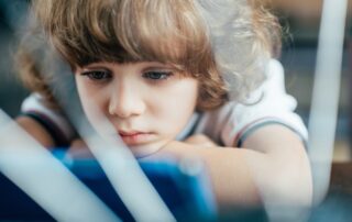 How to Prove a Co-parent Is Emotionally Abusing a Child in Maine portrayed by a sad girl with fighting parents behind her.